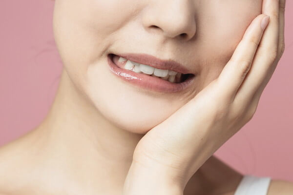 頬を抑える女性