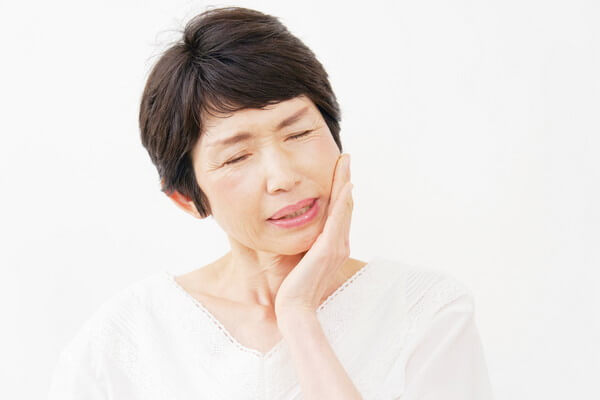 顎に痛みを感じる女性