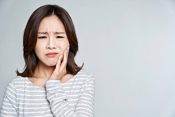 歯周病の痛み・症状に苦しむ女性